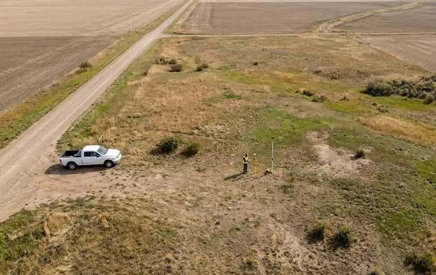 aerial-drone-view-of-surveyor-inspecting-vacant-rural-property-howard-county-nd - Sell My Land Fast in Howard County - - 2